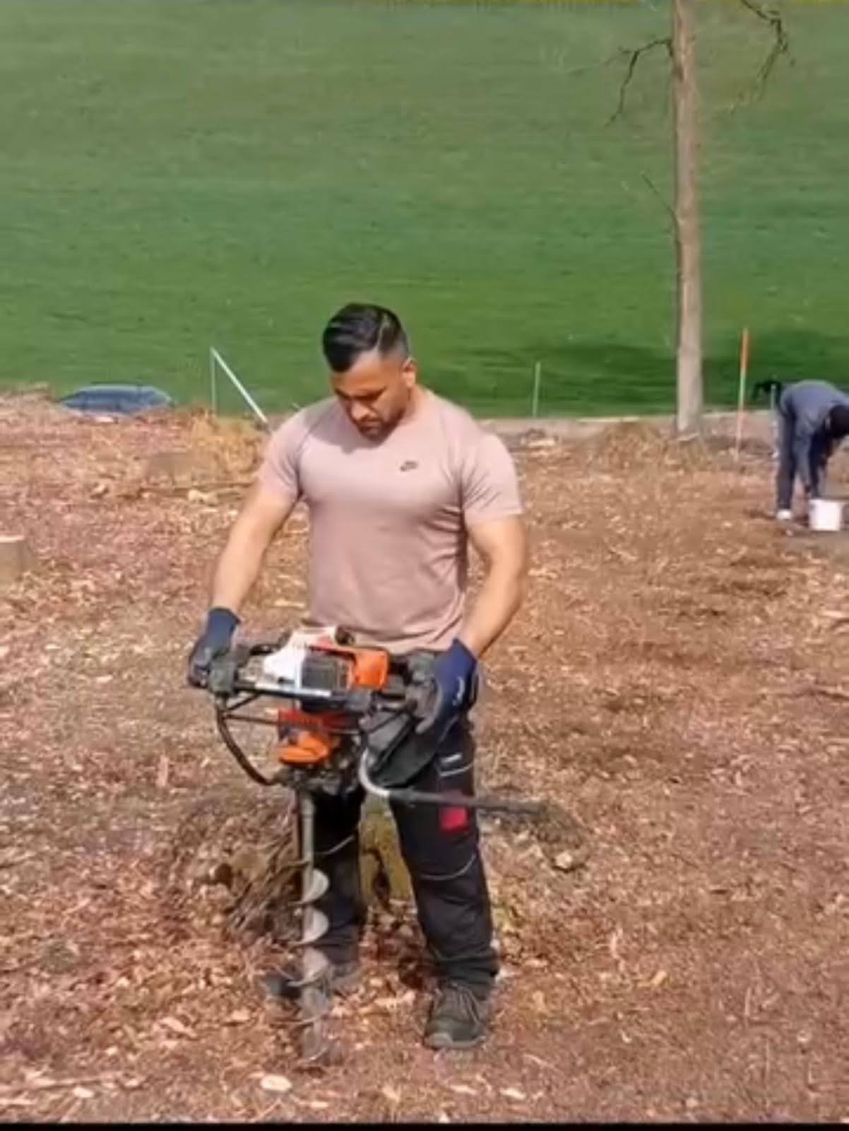 Watan Gartenservice bei Pflanzarbeiten mit einem Erdbohrer