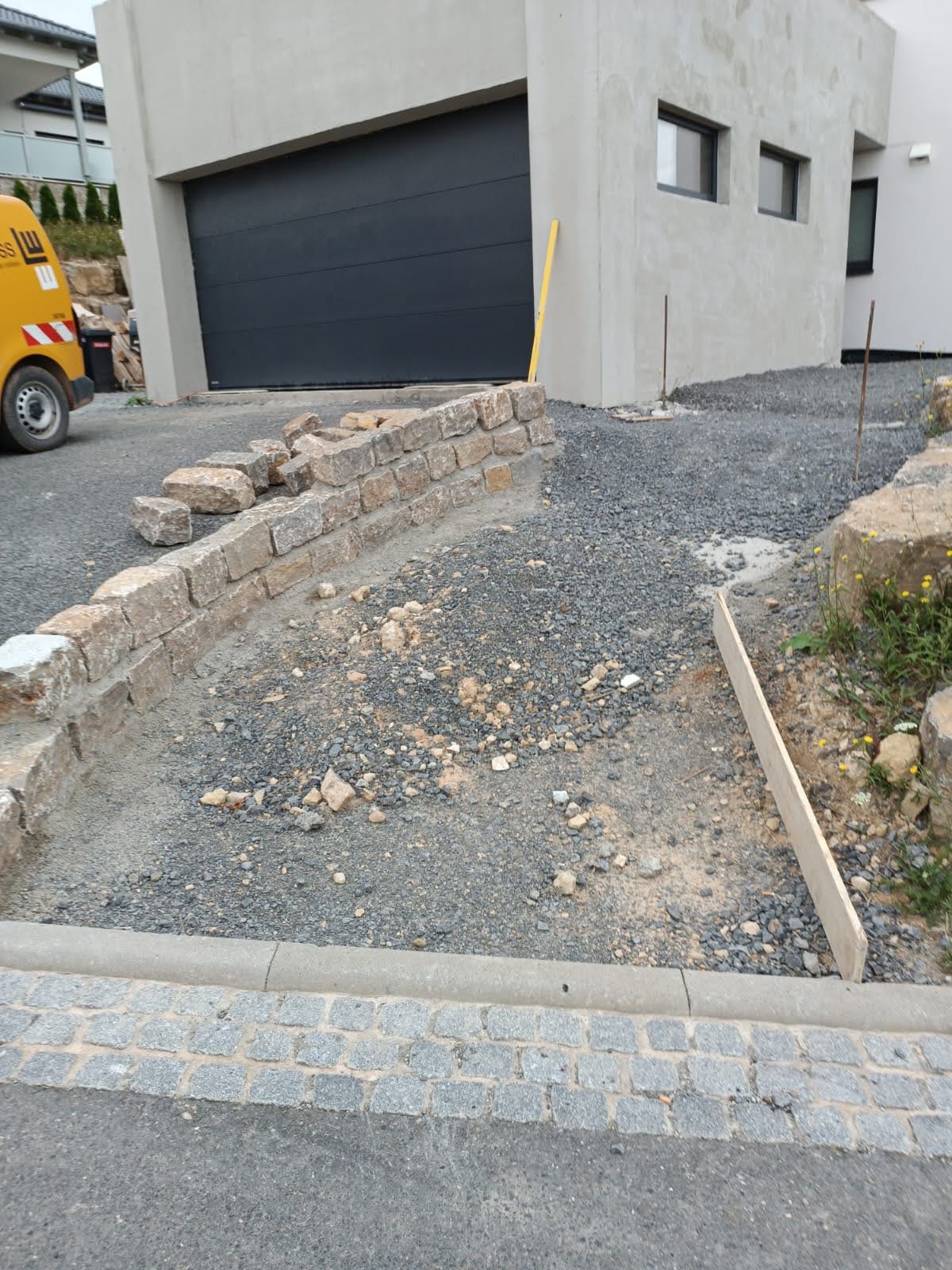 Natursteinmauer entlang einer neu angelegten Zufahrt während der Bauarbeiten